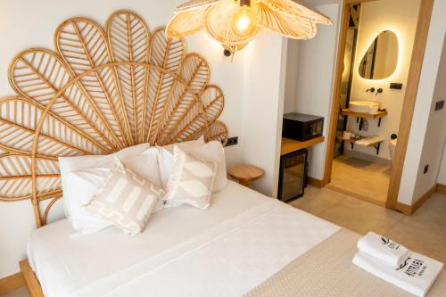 a bedroom with a large white bed with a wooden headboard at Kotraba Alacati Hotel in Alacati