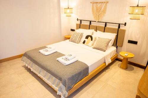 a bedroom with a bed with two towels on it at Kotraba Alacati Hotel in Alacati