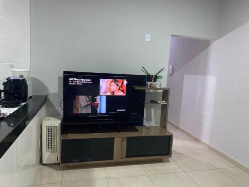 a flat screen tv sitting on a stand in a room at Casa Bela Vista in São Roque de Minas