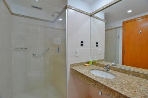 y baño con lavabo y ducha. en Comfort Hotel Taguatinga - Flat Preferido c/ Wifi, en Brasilia