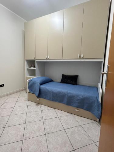 Schlafzimmer mit einem Bett mit blauer Bettwäsche und weißen Schränken in der Unterkunft Casa Vacanze Suli e Mari in Porto Empedocle
