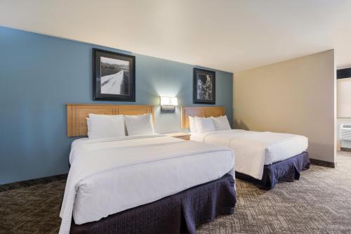 two beds in a hotel room with blue walls at Best Western Golden Spike Inn & Suites in Hill City