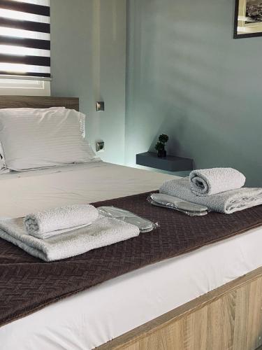 a bed with two towels on top of it at Keskos Luxury Apartment in Athens