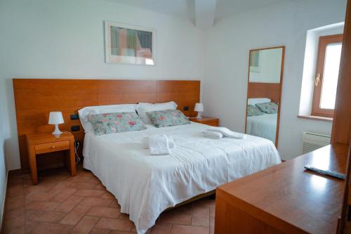 1 dormitorio con 1 cama blanca grande y espejo en L'antico gabbiano B&B, en San Casciano in Val di Pesa