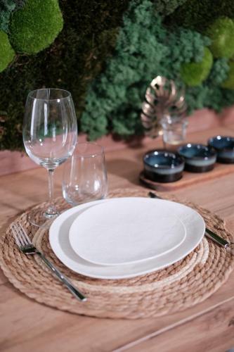 - une table avec une assiette blanche et deux verres à vin dans l'établissement L'Échappée Verte - Hyper Centre - Tout inclus, à Rouen