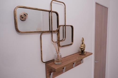 un miroir sur un mur à côté d'une étagère en bois dans l'établissement L'Échappée Verte - Hyper Centre - Tout inclus, à Rouen