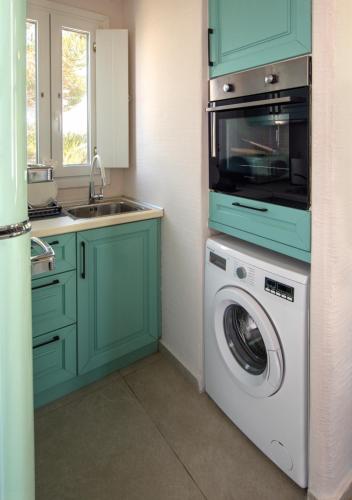 a kitchen with a washing machine and a sink at Artemis by Kallisto Royal Suites in Ornos