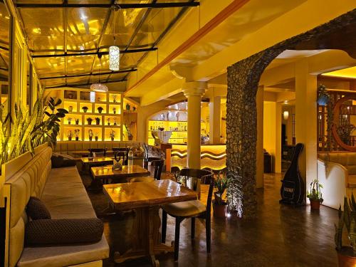 um restaurante com mesas e cadeiras e uma guitarra em Hotel Golden Orchid em Darjeeling
