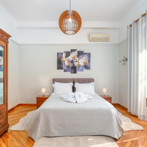 a bedroom with a white bed with two towels on it at Plaka Sofi Suite in Athens