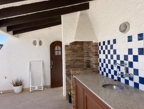uma cozinha com lavatório e azulejos azuis e brancos em Apto. Ses Ancolles Vistas Mar em Cala Morell