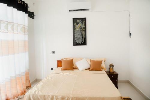 um quarto com uma cama grande e almofadas laranja em Villa Water View em Bandaragama