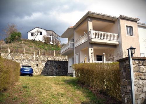 a house with a car parked in front of it at Villa Mira in Ballaban