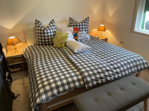 a bed with a checkered blanket and pillows on it at Stupa-Rezi-Tatika-Haz in Zalaszántó