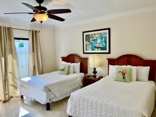 a bedroom with two beds and a ceiling fan at Colony Club Inn & Suites in Nassau