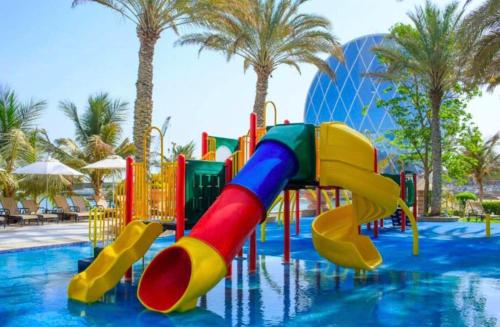 un parque acuático con un tobogán colorido en una piscina en Al Raha Beach Hotel - Superior Room DBL - UAE, en Abu Dabi