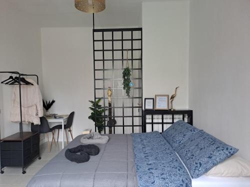 1 dormitorio con cama con edredón azul y escritorio en A due passi da Milano - Rho Fiera - Malpensa - Como, en Saronno