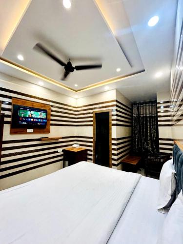 a bedroom with a bed and a ceiling fan at HOTEL HOLY CITY in Amritsar