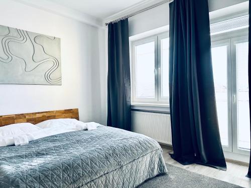 a bedroom with a bed with blue curtains at CARLA comfort stay with 2 bathrooms in Košice