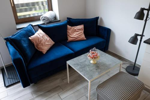 a blue couch in a living room with a table at Willa Gościnny Próg in Krościenko