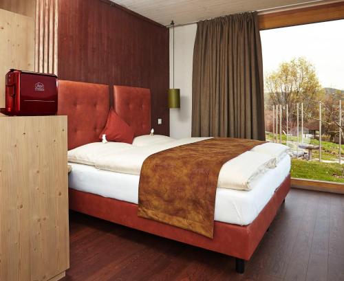 a bedroom with a large bed with a large window at Triad Wiener Alpen Bett DZ in Bad Schönau