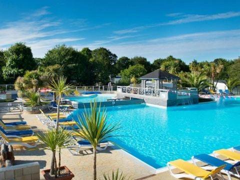 une grande piscine avec des chaises longues jaunes dans l'établissement Domaine de Kerlann 4 étoiles - MOBIL HOME 2 CHAMBRES - 2 SDB - 315, à Pont-Aven