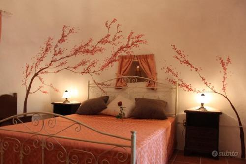a bedroom with a bed with a tree on the wall at Trullo Salento in Galatone