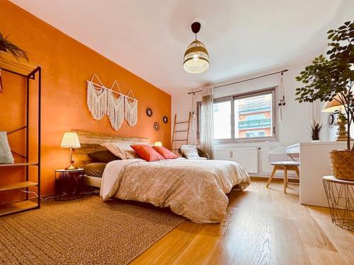 a bedroom with orange walls and a large bed at L'Oasis -T4 Garage Clim Terrasse WIFI Centre-Ville in Villefranche-sur-Saône