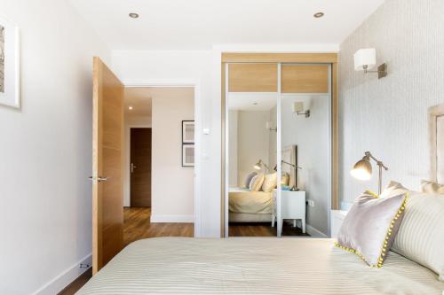 a bedroom with a large bed and a mirror at Mayfair Premium 1 Bed Apartment in London