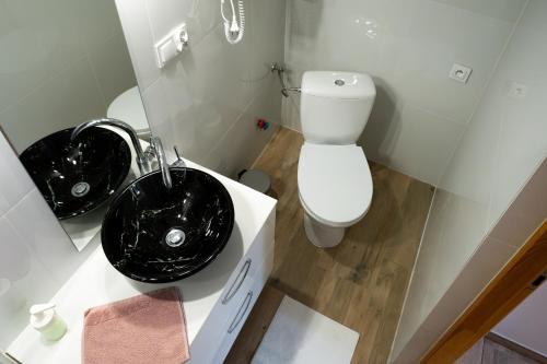 a bathroom with two black sinks and a toilet at Willa Gościnny Próg in Krościenko