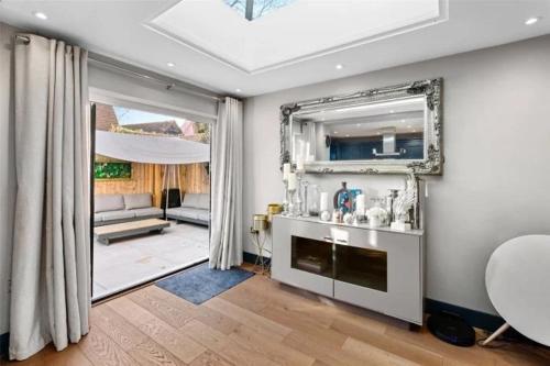 a living room with a sink and a mirror at St Chloe in Layer de la Haye