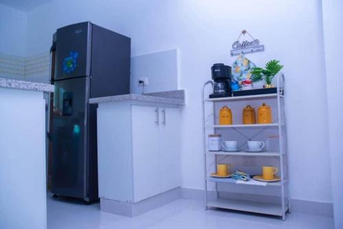 a kitchen with a black refrigerator and a shelf at LES RÉSIDENCES ROYAL LUXE ,3C in La Viva