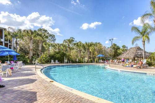 una piscina en un complejo con gente sentada alrededor en Bahama Bay Resort, en Kissimmee