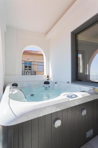 a large tub in a bathroom with a large window at Marina Apartments in Kardamili