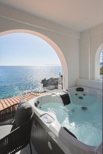 a hot tub on a balcony with the ocean at Marina Apartments in Kardamili