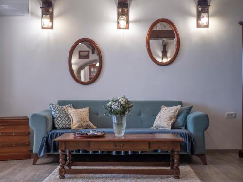a living room with a blue couch and two mirrors at Casa Pastrovici del Mare in Petrovac na Moru