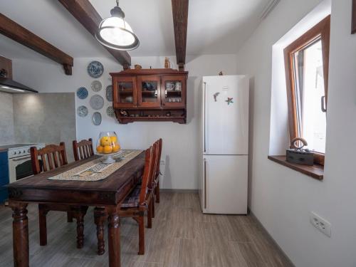 a kitchen with a table and a white refrigerator at Casa Pastrovici del Mare in Petrovac na Moru