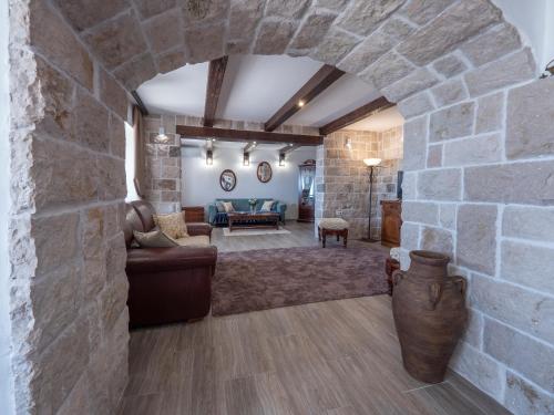 a large living room with a stone wall at Casa Pastrovici del Mare in Petrovac na Moru