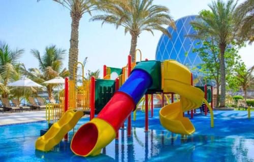 un parque acuático con un tobogán colorido en una piscina en Al Raha Beach Hotel - Gulf View Room SGL - UAE en Abu Dabi