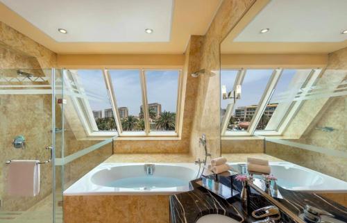y baño grande con bañera y ducha. en Al Raha Beach Hotel - Gulf View Room SGL - UAE, en Abu Dabi