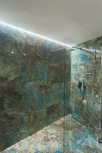 a bathroom with a shower with a glass shower stall at Marina Apartments in Kardamili