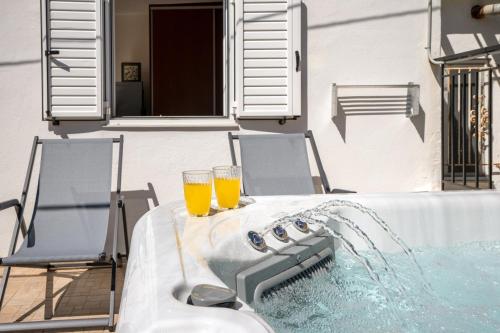 two glasses of orange juice sitting on a table next to a tub at House Aggeliki Private Hot Tub in Kissós