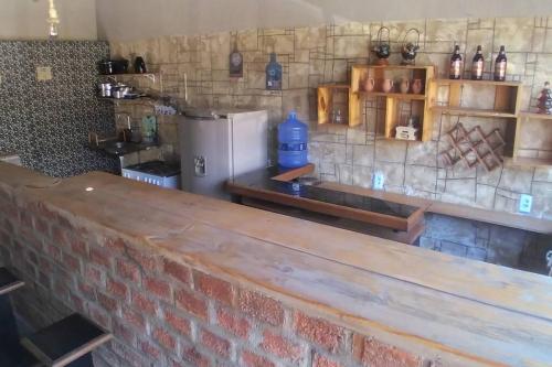cocina con pared de ladrillo y nevera en Pousada Encosta da Fé en Juazeiro do Norte