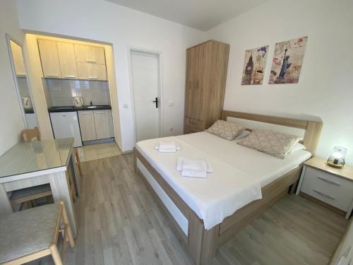 a small bedroom with a bed and a kitchen at Guesthouse Apartments Čenić in Budva
