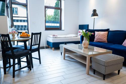 a living room with a blue couch and a table at Willa Gościnny Próg in Krościenko