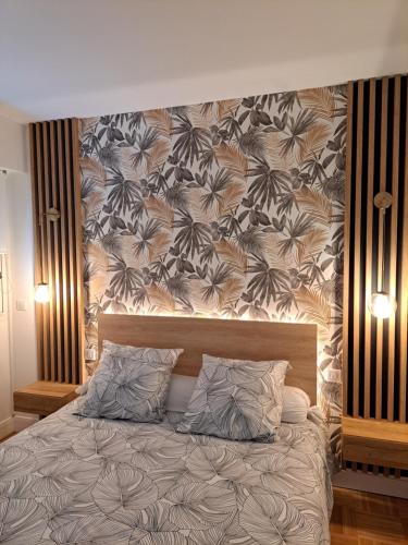 a bedroom with a large bed with a wall at Appartement de standing in Créteil