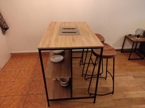 a wooden table with two stools in a room at L'orchidée studio proche centre in Châteauroux
