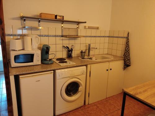 a kitchen with a washing machine and a microwave at L'orchidée studio proche centre in Châteauroux