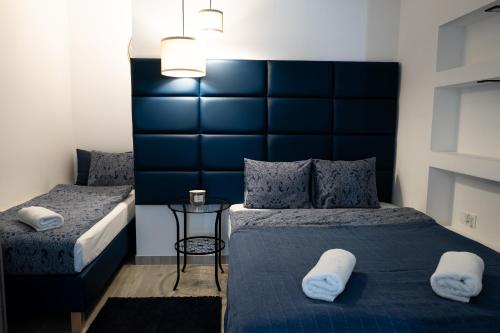 a bedroom with two beds and a blue headboard at Willa Gościnny Próg in Krościenko