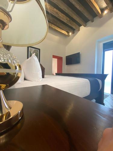 a bedroom with a bed and a table with a lamp at HOTEL BOUTIQUE CASONA 65 in Puebla