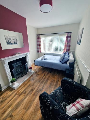 a living room with a bed and a fireplace at Beautiful 3BR Home with Garden & Gym in Hull